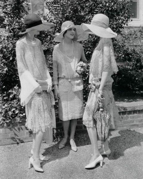 Tre donne eleganti degli anni Venti con ampi cappelli