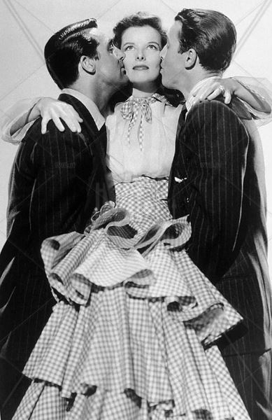 Katharine Hepburn con un vestito fantasia gingham abbraccia Cary Grant e James Stewart nel film "Scandalo a Philadelphia", 1940