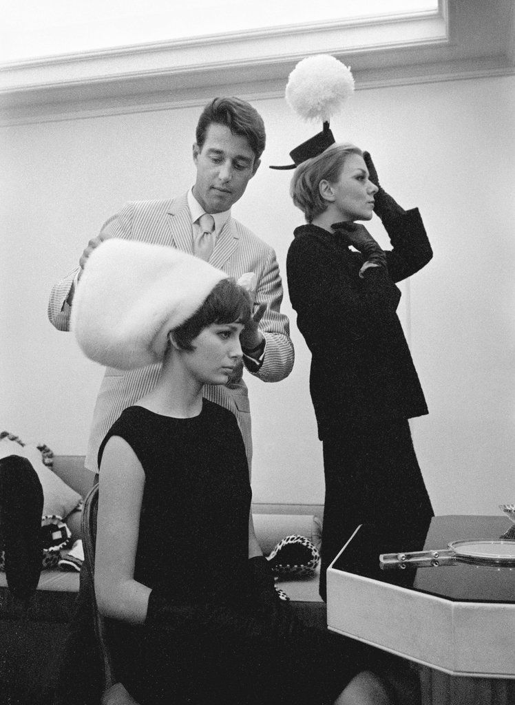 Halston aggiusta un grande cappello sulla testa di una modella, 1965