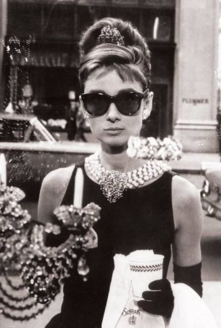 Audrey Hepburn indossa il tubino nero con lunghi guanti neri, collana di perle e grandi occhiali da sole nel film "Colazione da Tiffany" 