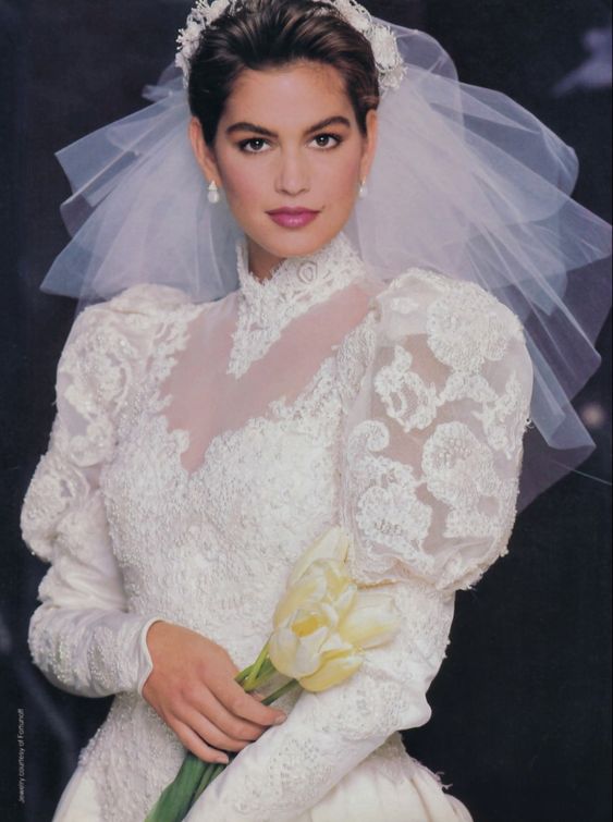 Cindy Crawford indossa un abito da sposa con ricami in pizzo e velo, 1988 circa 