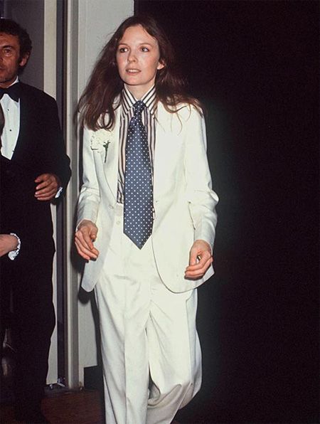 Diane Keaton indossa un completo maschile bianco con camicia a righe e cravatta a pois, anni Settanta.